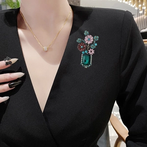 Baroque style vase brooch with pink flowers and emerald green crystal on black fabric