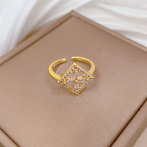 Macro shot of gold adjustable ring featuring pink petal gemstones and white cubic zirconia