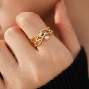 Makro-Detail von 18k vergoldetem mehrlagigem Ring mit Perlen und Zirkonia-Steinen