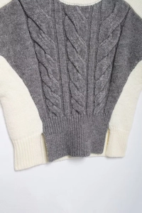 Close-up of cable knit texture and gray contrast patchwork on sleeveless sweater