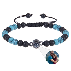 Detail of custom projection stone bracelet with black matte beads and adjustable braided cord