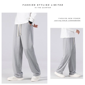Detail of grey casual pants featuring an elastic drawstring waistband and a loose straight fit