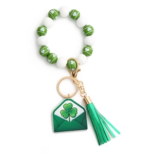 Close-up of Saint Patrick's Day wood bead keychain with shamrock pattern and leather tassel