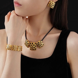 Vintage leopard print jewelry set with gold necklace, earrings and bracelet on model