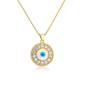Detailed close-up of golden evil eye pendant with blue enamel and cubic zirconia