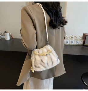 Detail of plush bucket bag with amber bead accents and a slim leather shoulder strap