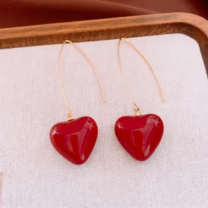 Boucles d'oreilles minimalistes en or avec pendentifs cœur en émail rouge vif
