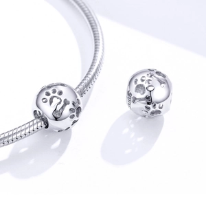 Macro shot of S925 sterling silver bead charm with hollow pet paw and bone engraving