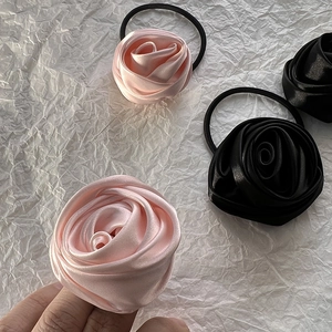Detailed view of pink and black satin rose hair ties with high elasticity bands