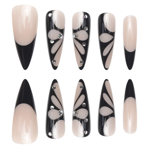 Long stiletto press-on nails in black and nude with butterfly rhinestone accents