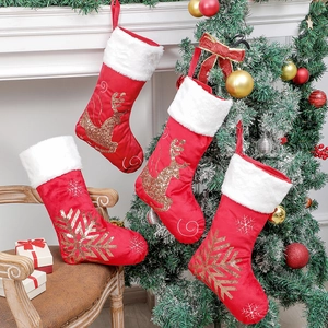 Set of four red velvet Christmas stockings with golden reindeer and snowflake embroidery