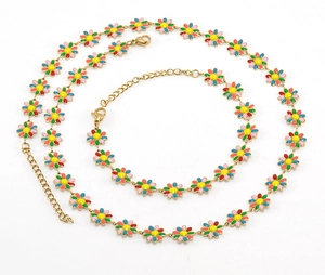 Détail d'un ensemble de bijoux en acier doré avec pendentifs de marguerites en émail coloré