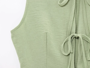 Detail of green textured fabric and tie-up design on women's vest and wide-leg trousers