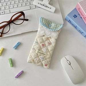 Close-up of quilted beige cotton eyeglasses pouch with lace trim and bunny print