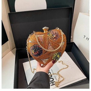 Detail of golden heart clutch bag with sequins, floral beadwork and chain strap