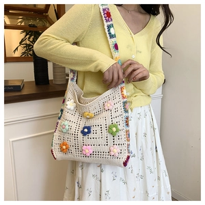 Detailed close-up of handmade crochet bag showing vibrant 3D flower patterns and texture