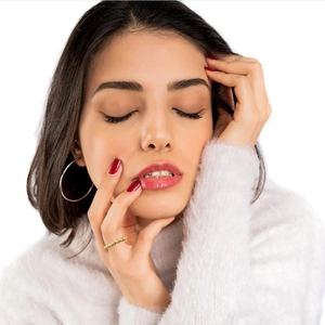 Close-up of a gold rotating bead ring worn by a model, showing creative relief design
