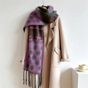 Winter faux cashmere scarf with purple green polka dots and fringe, draped on a coat