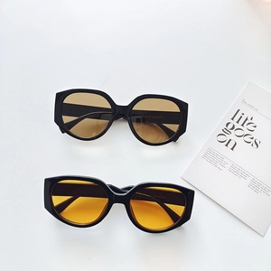 Oversized black frame sunglasses in orange and brown tints for a stylish outdoor look