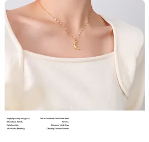 Detail of 18k gold plated titanium steel crescent moon pendant with hammered texture