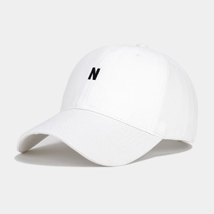 Close-up of the black 'N' letter embroidery on the white cotton twill baseball cap