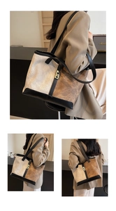 Detail of a large suede tote bag with contrast leather trim and long shoulder straps