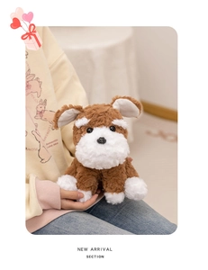 Close-up of curly plush Schnauzer puppy dog doll held by model in warm cozy lighting