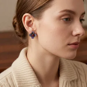 Boucles d'oreilles fleurs vintage avec cristaux violets et pierre rouge sur mannequin