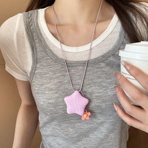 Dettaglio del ciondolo a stella viola con testo e fiore rosa su una collana di tendenza