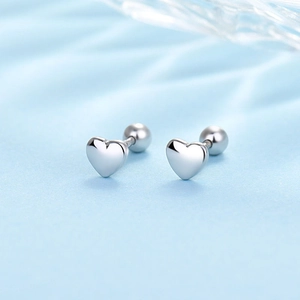 Macro view of silver heart stud earrings with secure screw-back on blue silk fabric