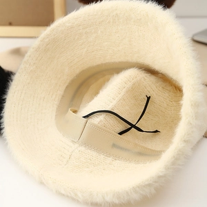 Plush cream knit bucket hat featuring soft faux fur texture and adjustable interior drawstring