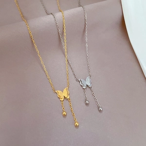 Elegant gold and silver titanium steel butterfly tassel necklaces on pink fabric