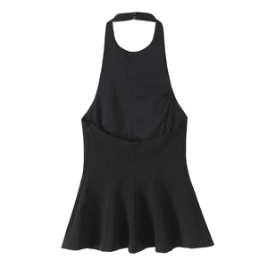Detail of a black halter neck top with elastic ruffled hem and backless design on white