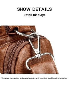Detail of silver metal hook and D-ring on brown lychee texture leather handbag strap