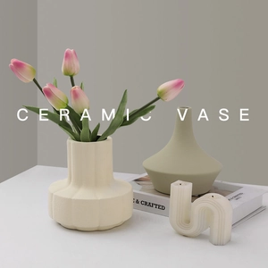 Nordic cream ceramic vases with vertical wave texture and tulips on a minimalist table