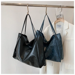 Detail of large PU leather tote bags in black and navy blue for commute style