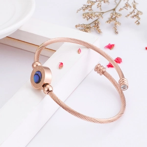 Detail of rose gold stainless steel wire bracelet with Roman numerals and blue shell inlay