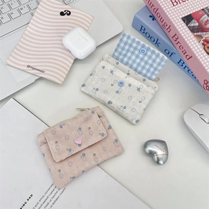 Vue à plat de porte-cartes en tissu floral avec boutons cœur sur un bureau soigné