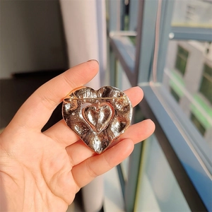 Close-up of the gold heart brooch back showing pin fastener and metal texture