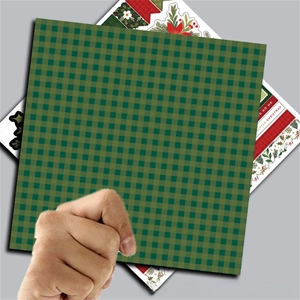 Detail of Christmas green plaid paper with festive stickers for scrapbooking