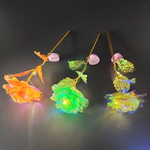 Three gold foil roses with luminous light-up petals and heart-shaped bases in macro view