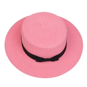 Top view of pink flat top straw hat with black ribbon bow and fine woven texture detail
