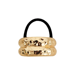 Detailed view of golden elastic hair tie featuring a hammered irregular texture metal ring