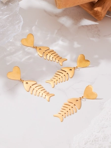 Macro detail of gold fishbone heart earrings displayed on a luxury marble surface
