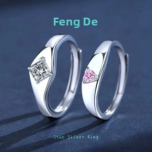 Close-up of S925 silver couple rings with heart pink and square white gemstones
