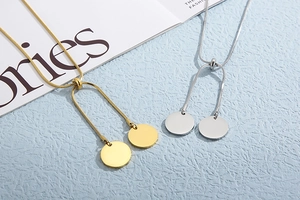 Detail view of adjustable gold and silver snake chain necklaces with round pendants