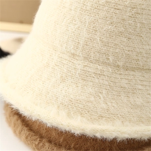Close-up of soft fluffy knit texture on this cream white winter bucket hat for women