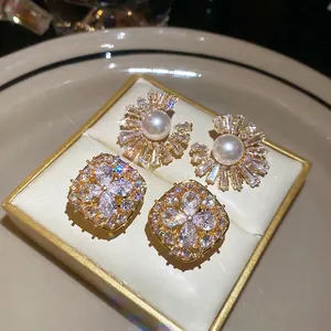 Elegant gold-plated pearl and cubic zirconia stud earrings with radiant starburst design