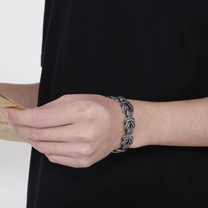 Gros plan sur un bracelet chaîne en acier style rétro avec finition argent antique au poignet