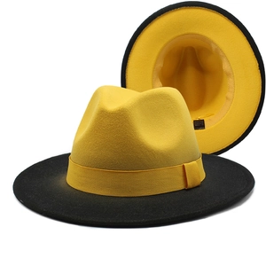 Detail of yellow and black two-tone fedora hat showing interior lining and brand label